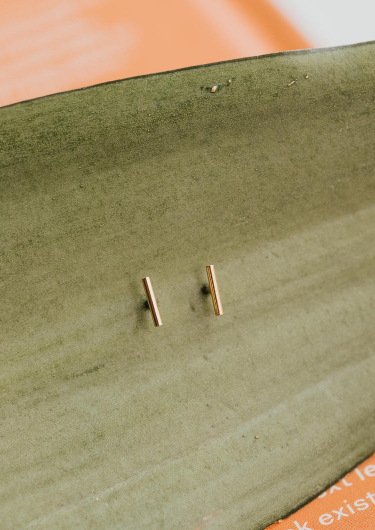 Small earrings in 14k gold fill in tiny bar stud style by Hello Adorn.