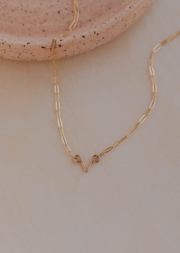 Gold necklace on a neutral background