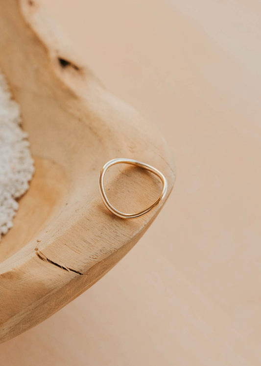 Gold ring on a wooden surface with a natural background