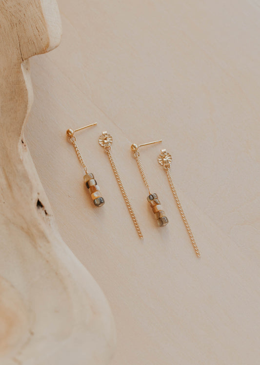 Pair of gold earrings on a neutral background