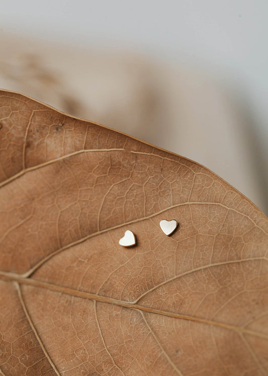Tiny heart earrings shown in 14k gold fill by Hello Adorn in a stud earring style.