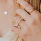 Close-up of a person wearing gold rings on a blurred background
