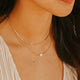 Close-up of a woman wearing gold jewelry with a blurred background