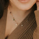 Close-up image of a stylish charm necklace featuring delicate charms and a shiny chain, perfect for adding a personalized touch to any outfit.