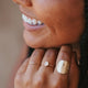 A gold ring stack with a 3 ring stack using a thin gold ring, a gemstone ring with a Rose Quartz stone, and the Supermoon Ring which is a hammered ring created to look like a moon ring by Hello Adorn.