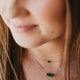 A model wearing multiple gemstone necklaces from Hello Adorn's Gemma Collection, these are green stone necklaces which are shown in 14k gold fill.
