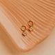 14K Gold Fill Grace Charms by Hello Adorn - pair of CZ star charms on gold huggies on ceramic dish