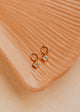 14K Gold Fill Grace Charms by Hello Adorn - pair of CZ star charms on gold huggies on ceramic dish