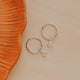 Sterling Silver Grace Hoops by Hello Adorn - pair of silver huggies with CZ star charms on ceramic prop