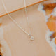 Sterling Silver Grace Necklace by Hello Adorn - tiny CZ pendant on silver chain against ceramic dish