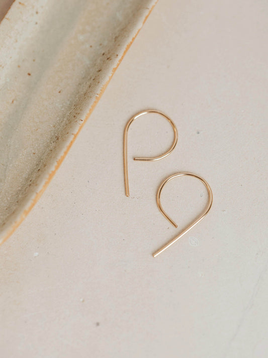 A pair of gold threader earrings hand-shaped by Hello Adorn to turn wire earrings into half hoop earrings in the MINI Swoops design.