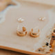 Gold hoop earrings on a decorative plate with a blurred background