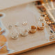Collection of gold earrings on a decorative plate with a blurred background