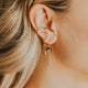 Close-up of a person wearing an earring with a blurred background