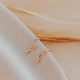 14k gold fill wavy ear climber earrings by Hello Adorn resting on a speckled ceramic dish