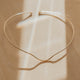 Gold necklace cuff on a beige background