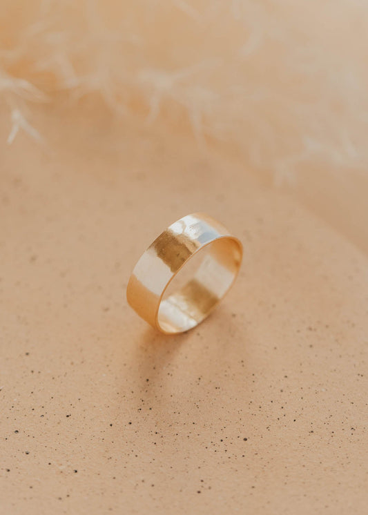 Gold ring on a soft beige background