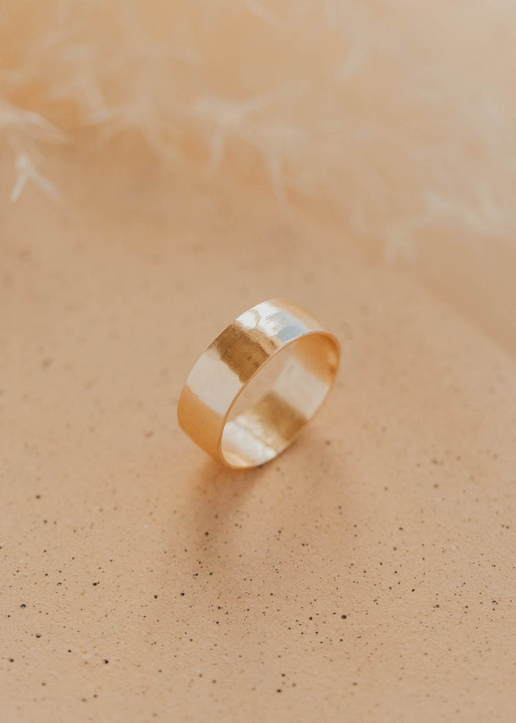 Gold ring on a soft beige background