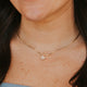 Close-up of a person wearing a delicate gold necklace with a small pendant.