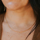 Close-up of a person wearing a gold chain necklace.
