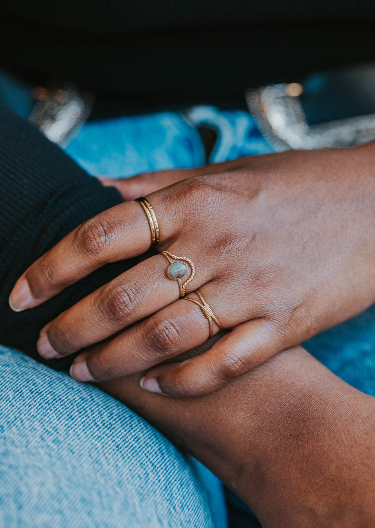 model wearing dune stacking ring with labradorite stone band