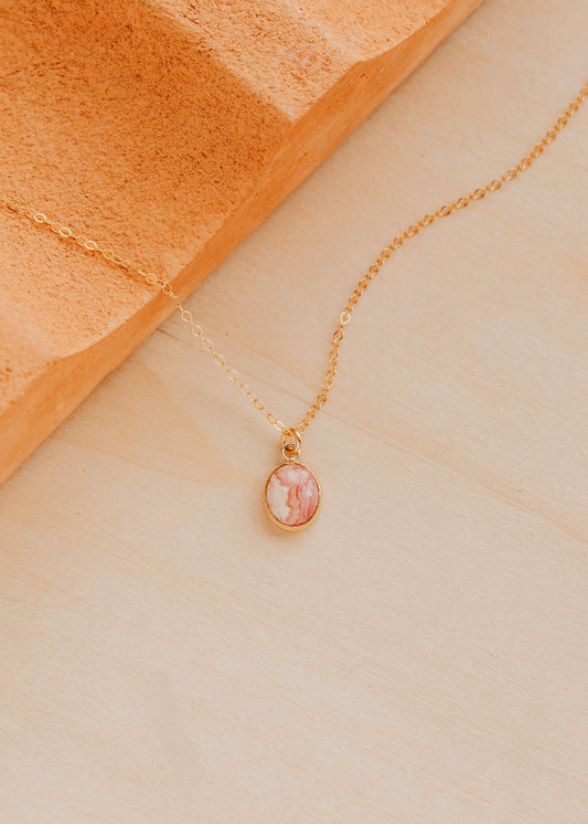 14K Gold Fill Rosalie Necklace by Hello Adorn - oval pink stone pendant on delicate chain against terracotta prop