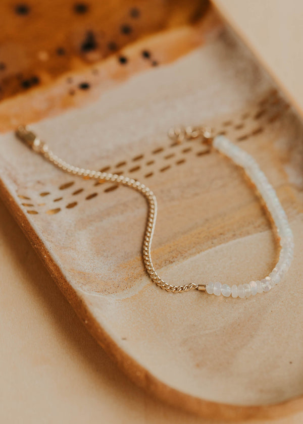 Gold bracelet on a textured beige surface