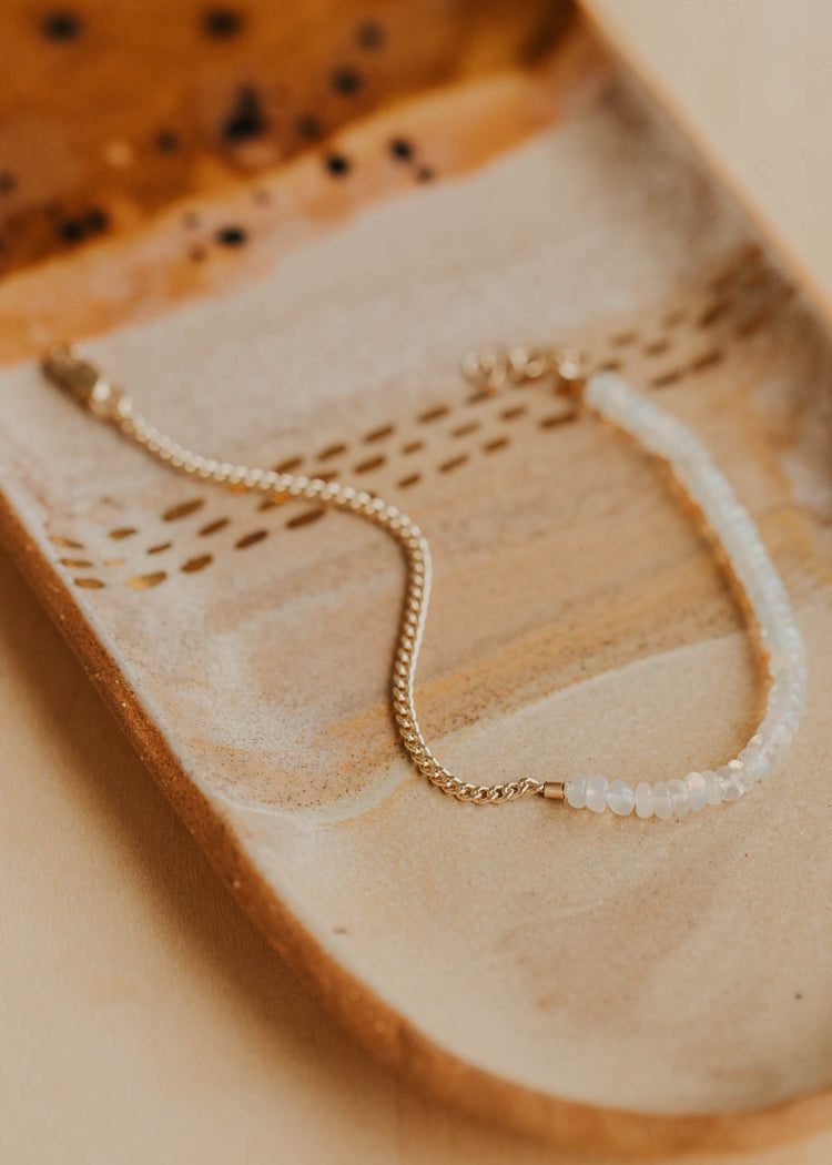 Gold bracelet on a textured beige surface