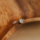 Silver ring with a blue stone on a wooden surface
