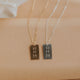 Two necklaces with rectangular pendants on a beige fabric background