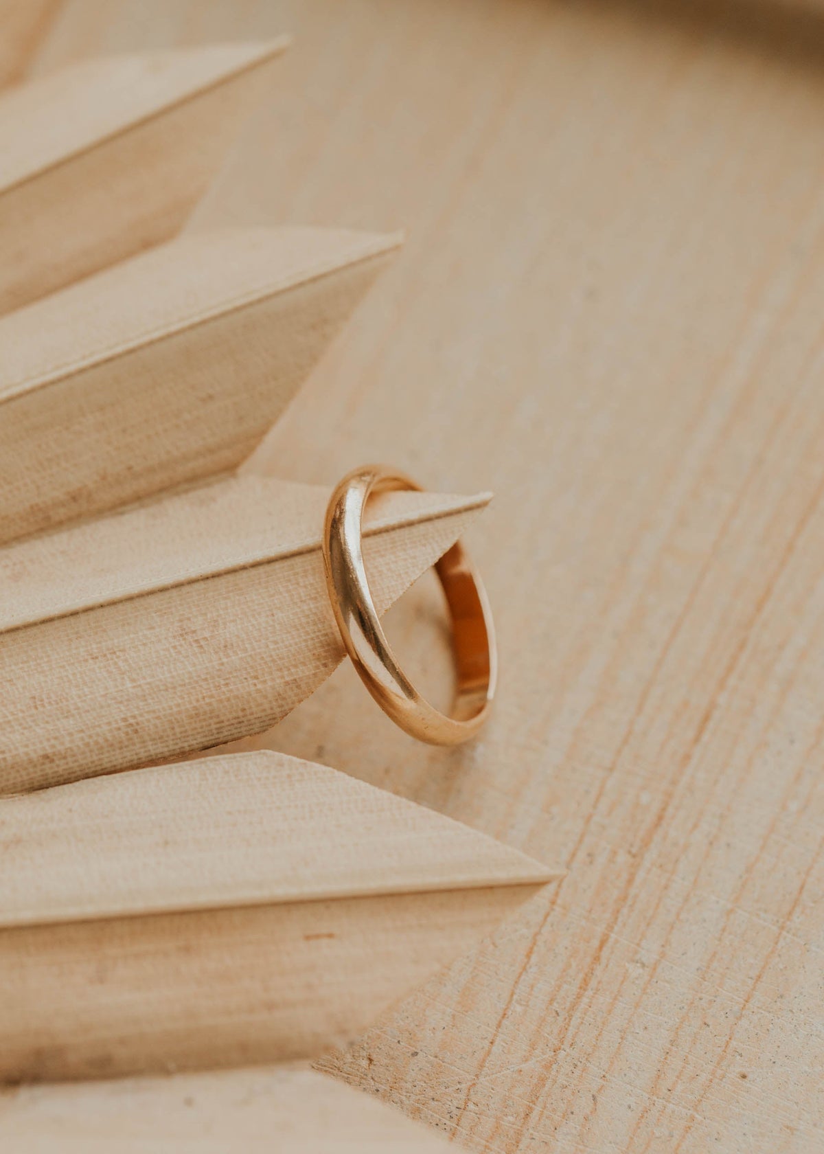 Gold ring on a wooden surface with geometric shapes