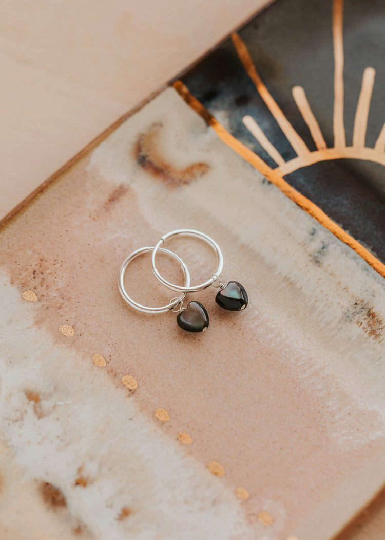 Silver earrings with black stones on a decorative plate