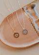 Three necklaces with heart pendants on a ceramic dish.