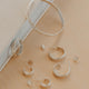 Silver hoop earrings on a beige surface