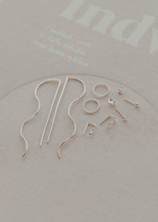 Gold earring hooks on a light gray background with 'indy' branding.