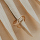 Gold ring on a textured beige surface