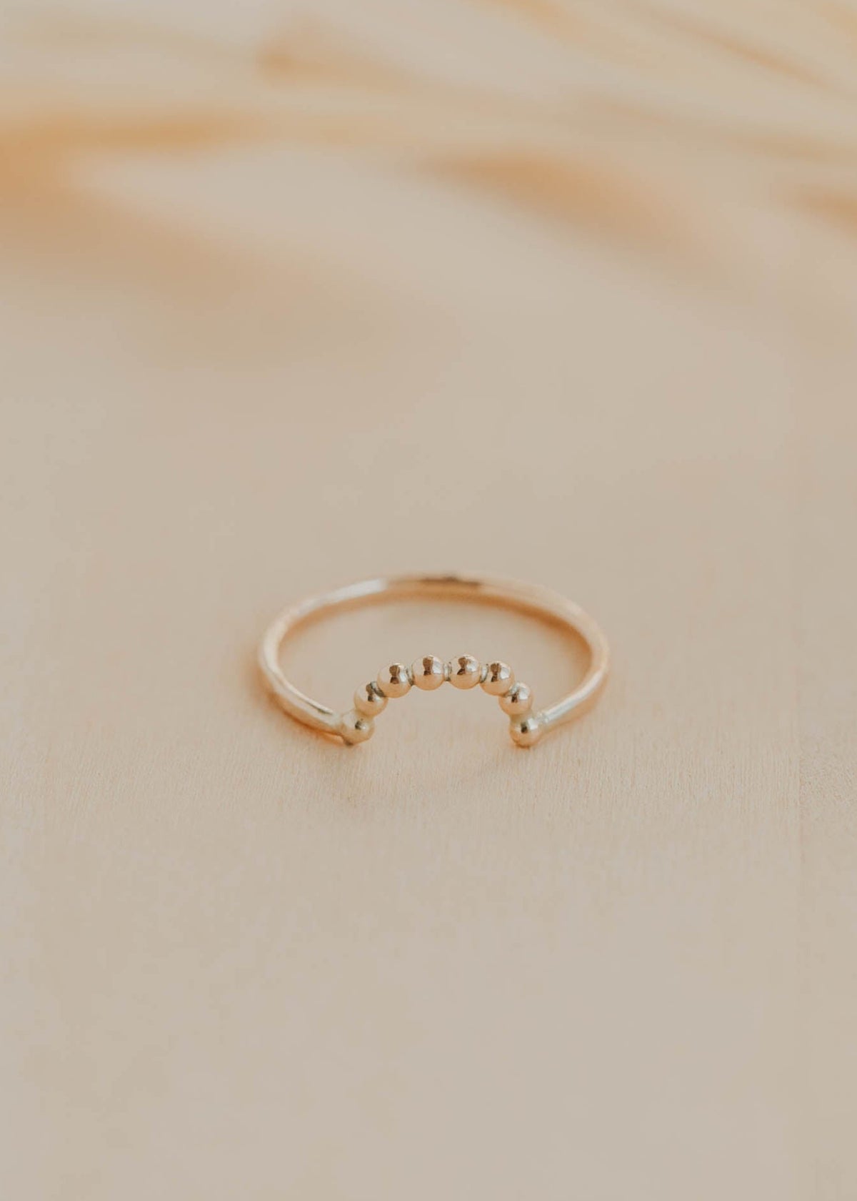 Gold ring on a beige marble surface