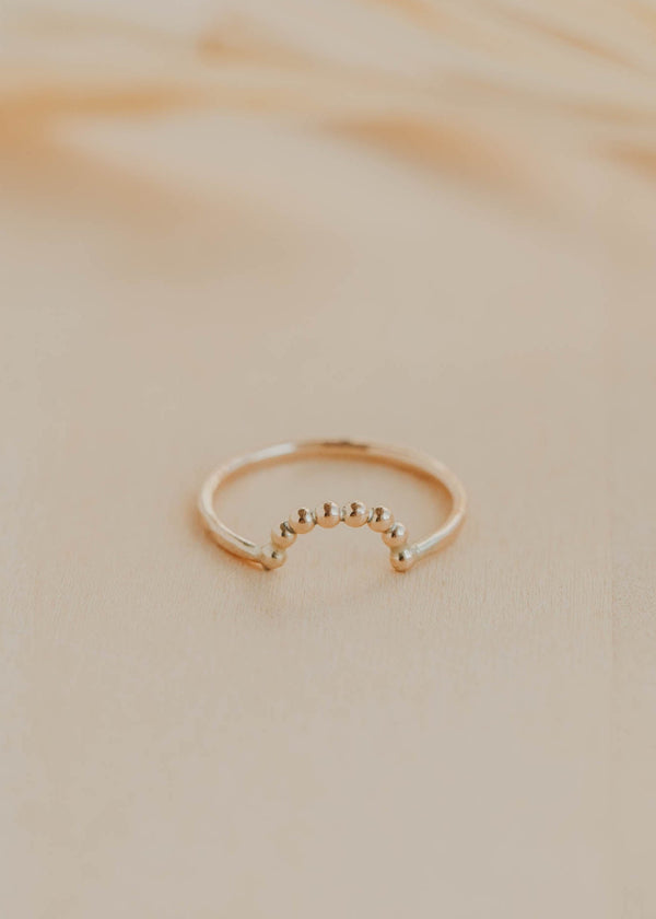 Gold ring on a beige marble surface