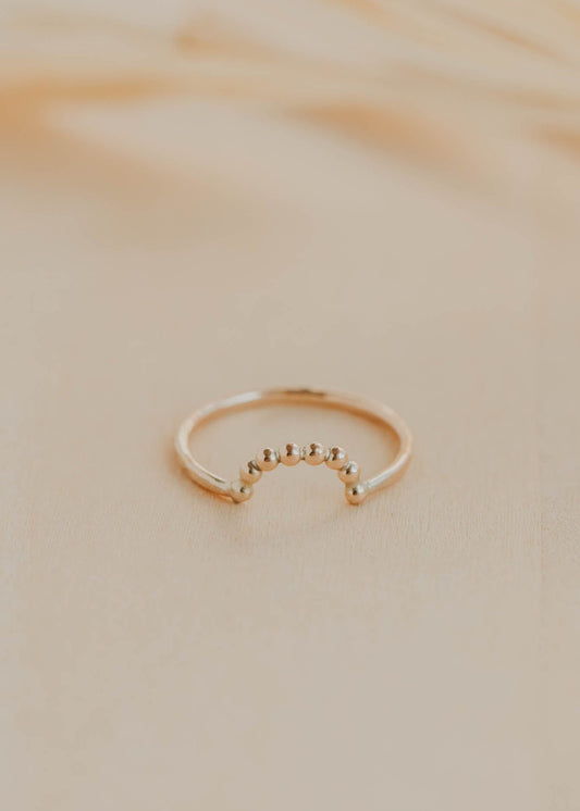 Gold ring on a beige marble surface