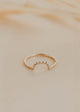 Gold ring on a beige marble surface