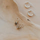 Three pairs of earrings on a wooden surface