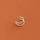 Silver nose ring cuff on a rust-colored background
