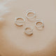Sterling silver tiny twist earrings by Hello Adorn on a beige brown stone