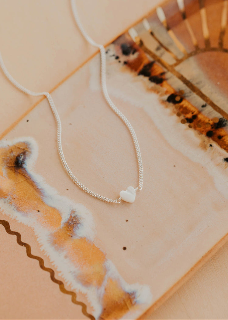 Necklace with a heart pendant on a decorative surface