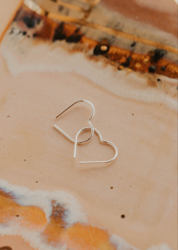 Silver earrings on a marbled surface