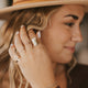 A gold and silver jewelry together bracelet stack paired with a gold ring stack using a hammered circle ring to create a moon ring as the statement ring, a squiggle ring, braided ring, two thin rings, wave ring, and a flat ring all handmade by Hello Adorn.