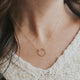 A model wearing the Full Circle Necklace handmade by Hello Adorn, a charm necklace with a circle pendant.