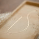 Delicate gold necklace in Herra chain style by Hello Adorn laying flat on a jewelry tray.