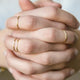Four Teeny-Tiny Band in 14k Gold Fill by Hello Adorn stacking rings shown styled on hands.