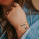 14kt Gold Fill minimalist chain bracelets on a young model with tattoos.